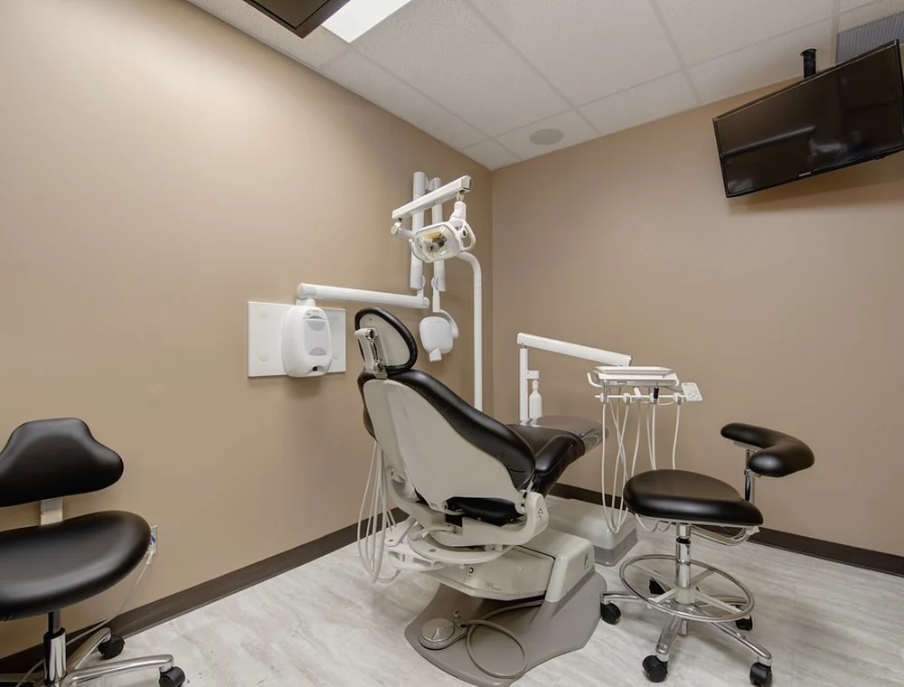 Dental operatory with chair, stools, and overhead screen